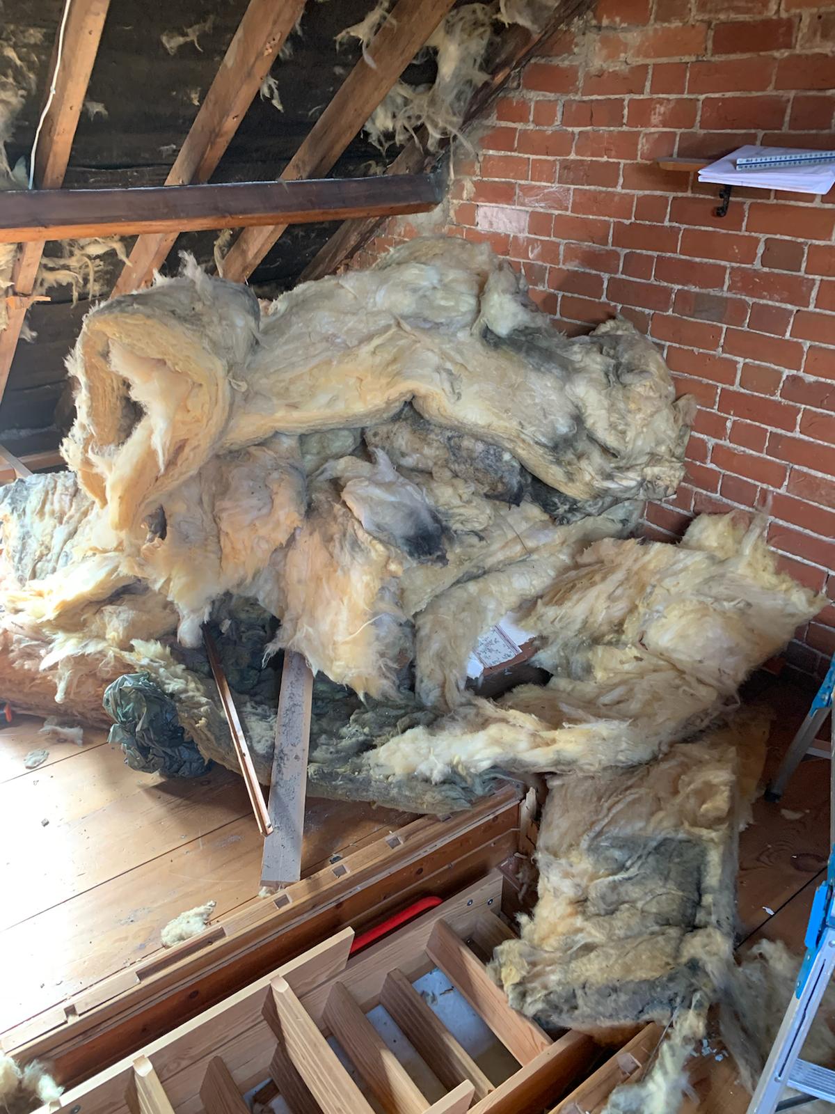 A partially cleared loft space with boxes and old items, ready for a professional loft clearance service.