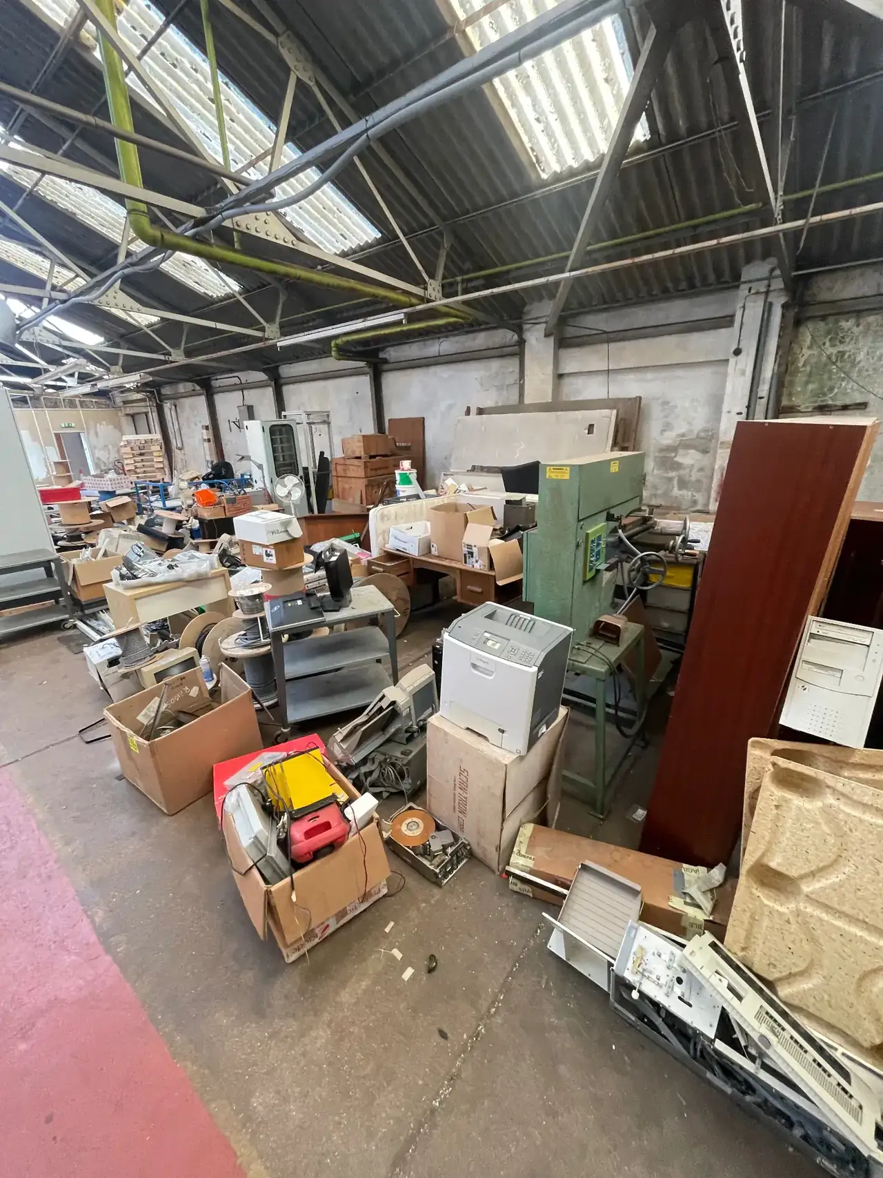 Boxes, pallets and old equipment piled inside a commercial unit