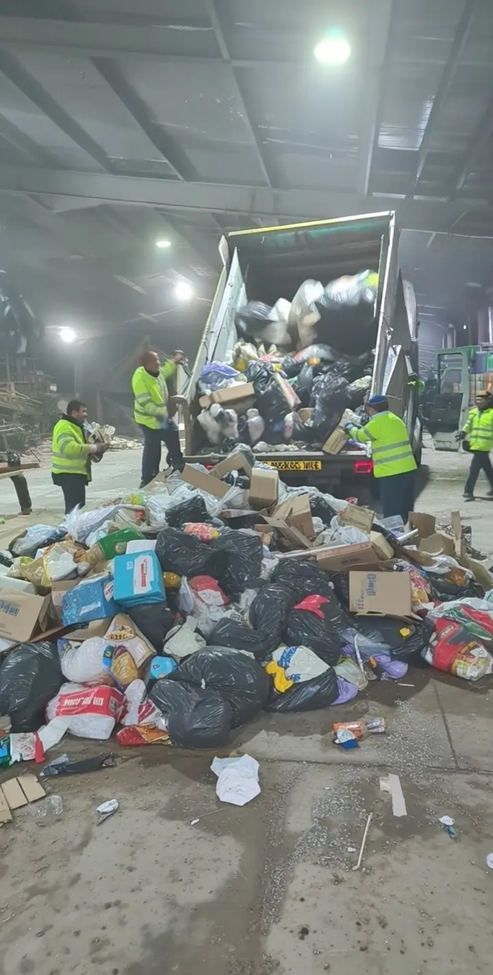 Crew in hi-vis jackets unloading bagged rubbish at a waste transfer station